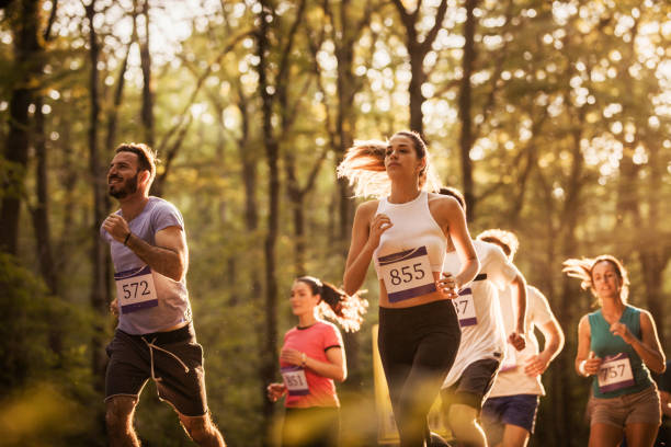 Group of marathon runners having a race through the forest. Group of marathon runners having a race through the forest.