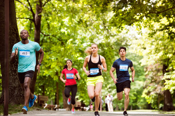 Group of young athletes running in green sunny summer park. Group of young athletes running in green sunny summer park.